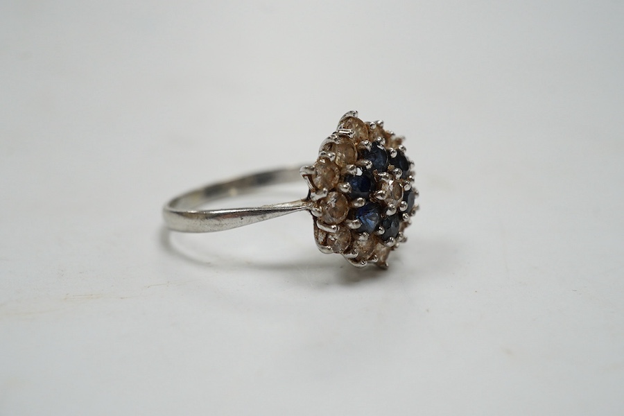 An 18ct white metal, sapphire and diamond set cluster ring, size O, gross weight 4.1 grams. Condition - fair to good